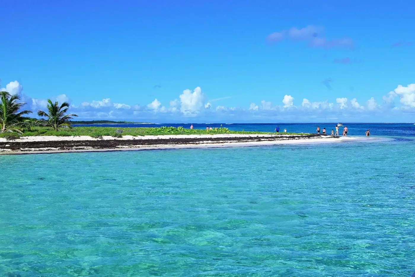 Lagon turquoise peu profond de Petite-Terre bordé d'une langue de sable blanc où marchent quelques visiteurs
