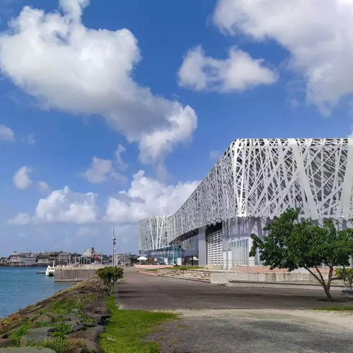 La façade en résille métallique blanche du Mémorial ACTe, au bord de l'eau à Pointe-à-Pitre