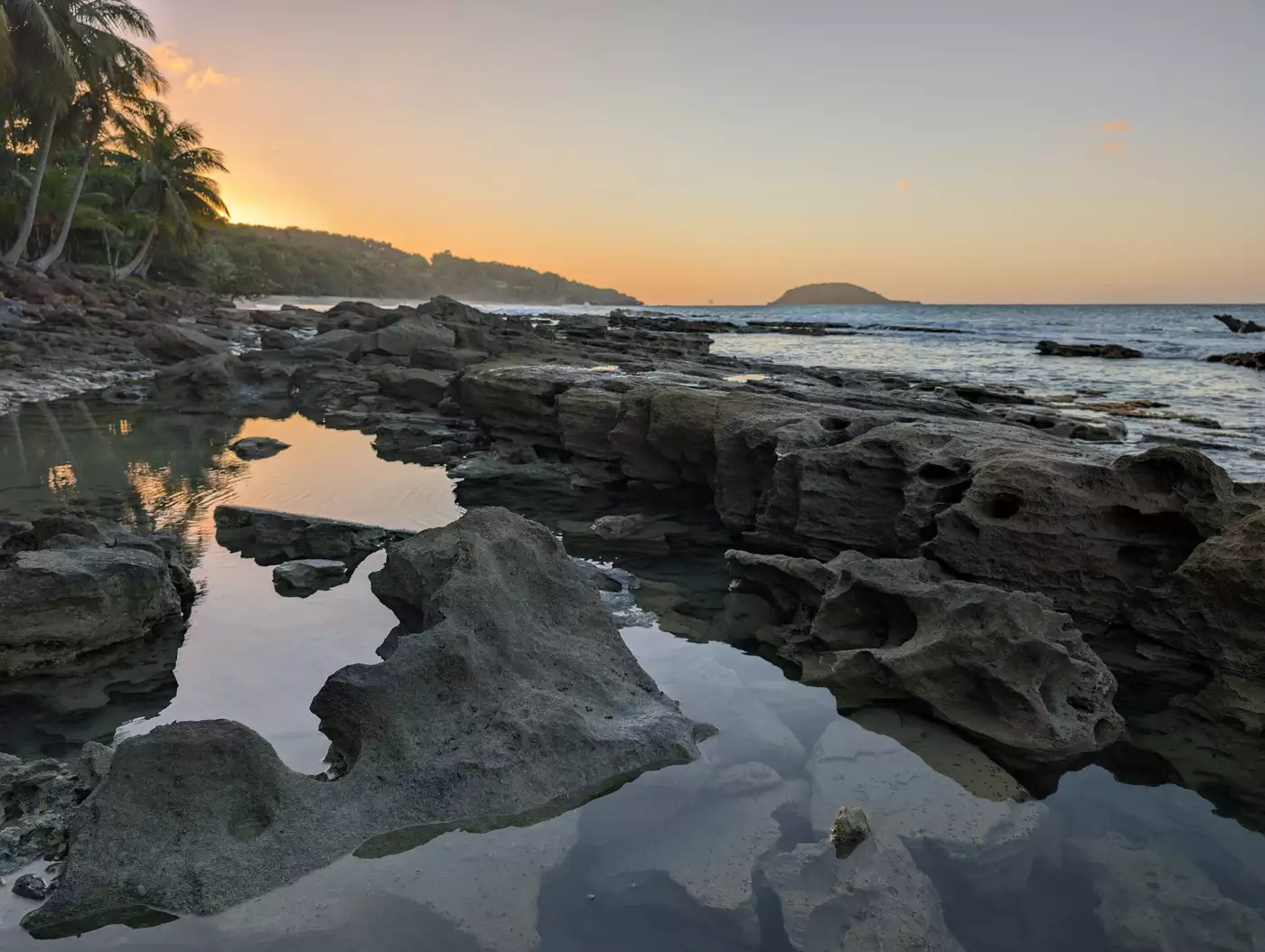 Affleurement rocheux et vasques d'eau au coucher du soleil sur la plage de Clugny, entre Deshaies et Sainte-Rose