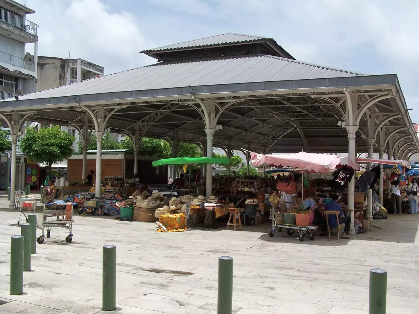 La halle métallique du marché central de Pointe-à-Pitre, étals de chapeaux de paille, paniers et madras sous la charpente