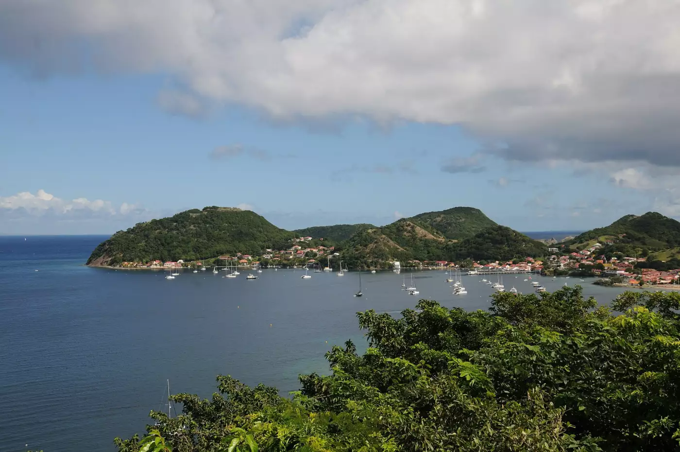 Baie des Saintes vue d'un belvédère, voiliers au mouillage et bourg de Terre-de-Haut au pied des mornes