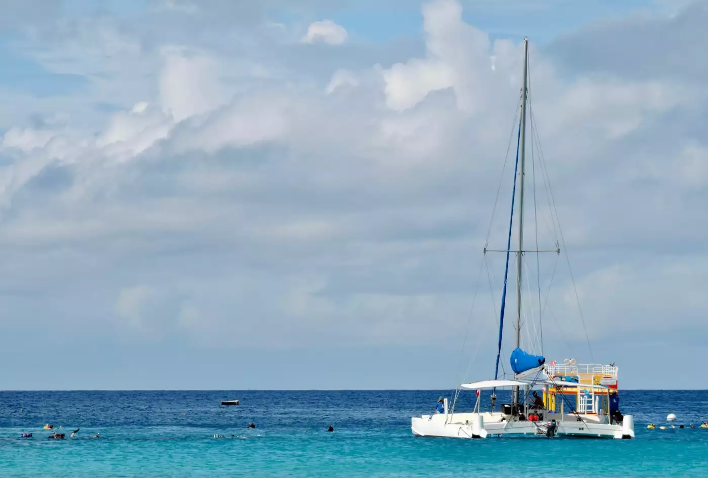 Catamaran au mouillage sur une mer turquoise des Caraïbes sous un ciel nuageux