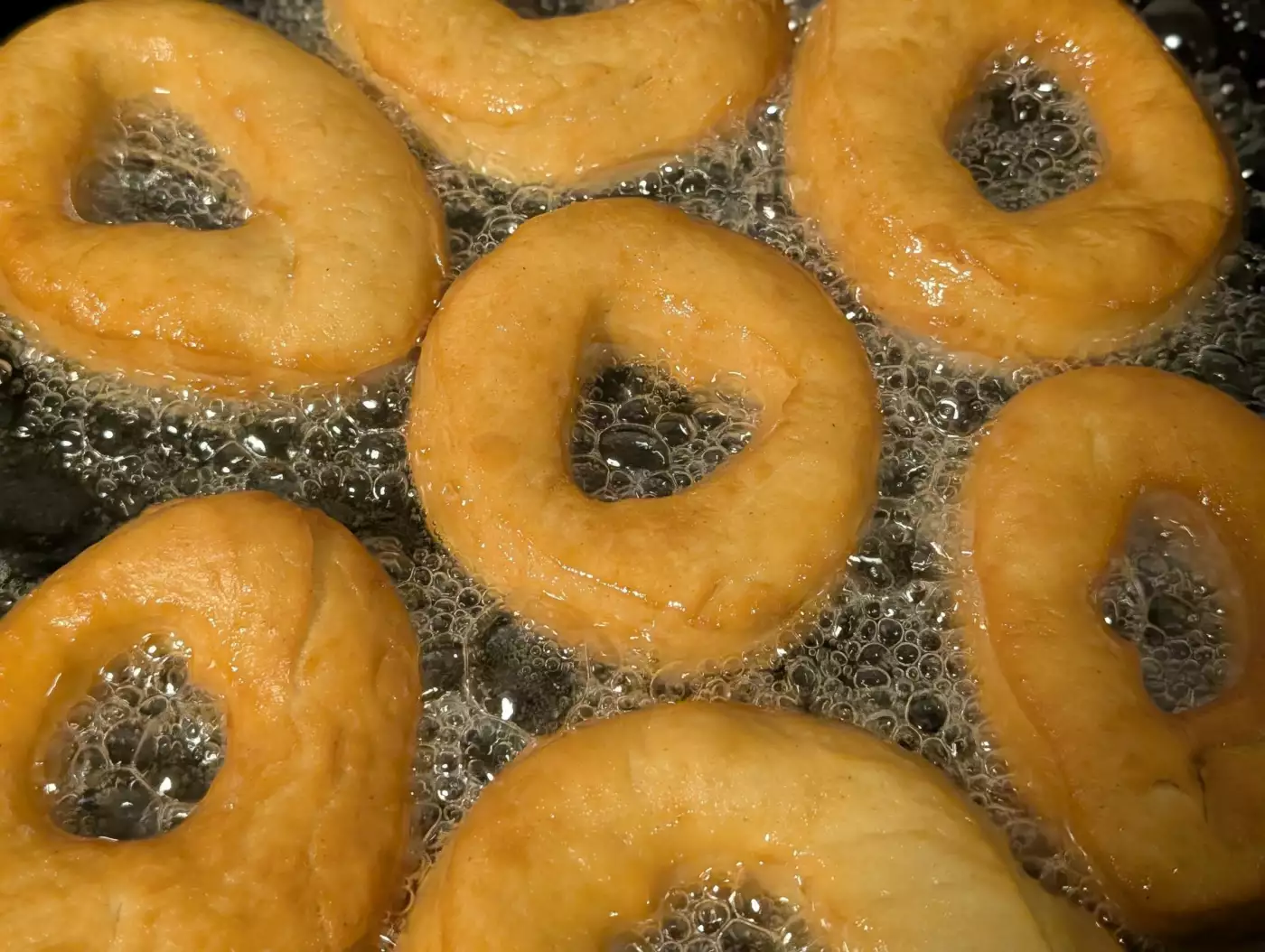 Gros plan de pâte dorée en train de frire dans un bain d'huile chaude