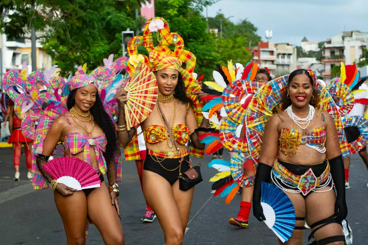 Groupe costumé de plumes et de couleurs vives défilant dans une rue lors d'un carnaval