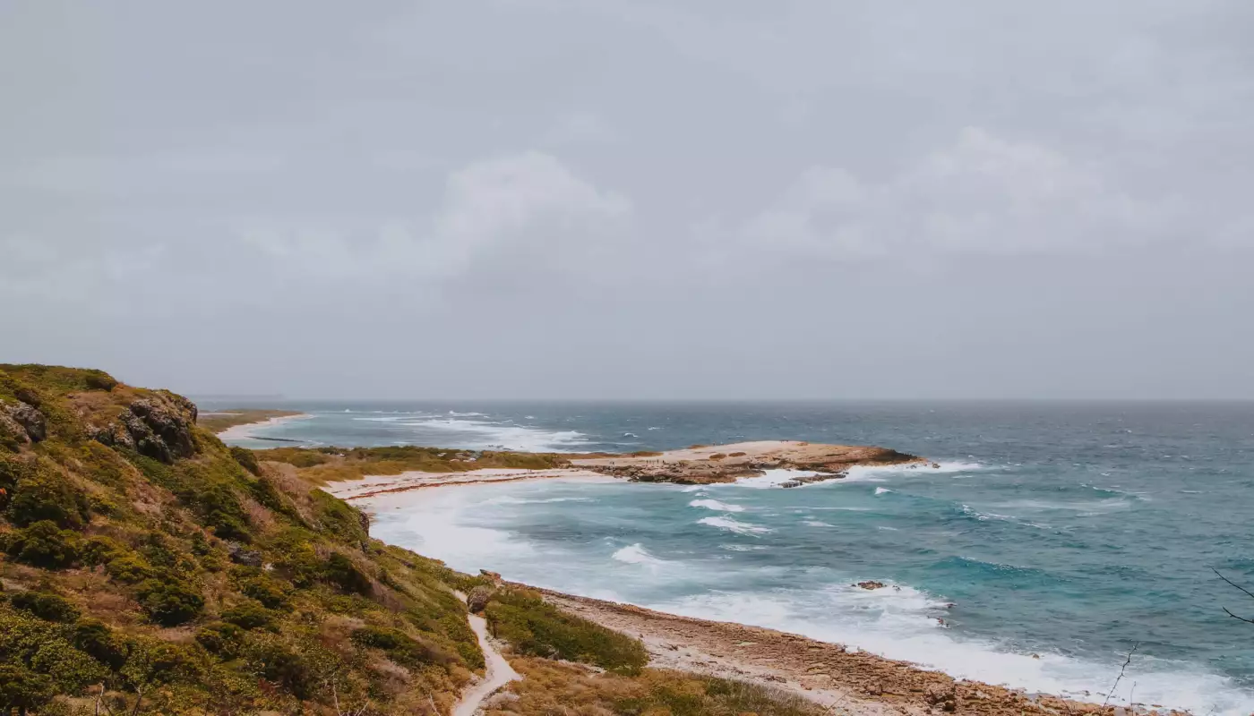 Sentier dans la végétation sèche au-dessus de criques battues par l'Atlantique