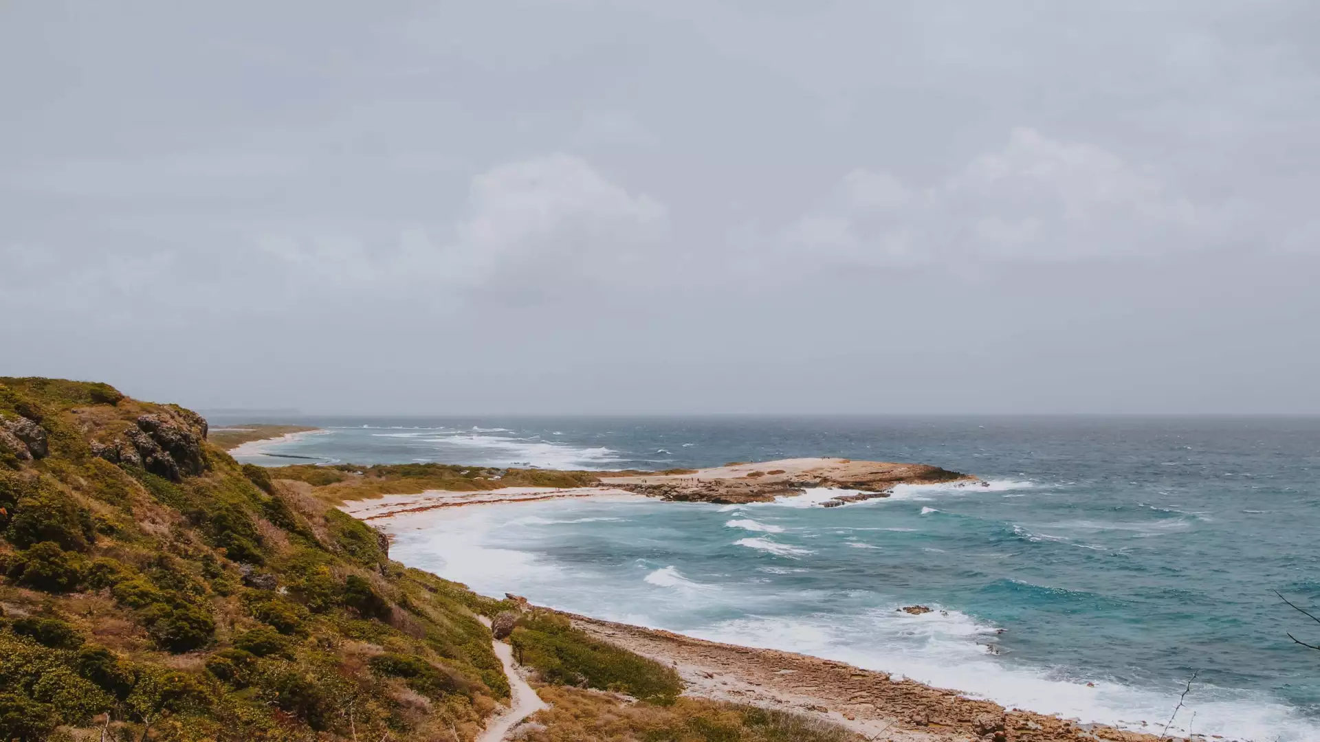 Sentier dans la végétation sèche au-dessus de criques battues par l'Atlantique