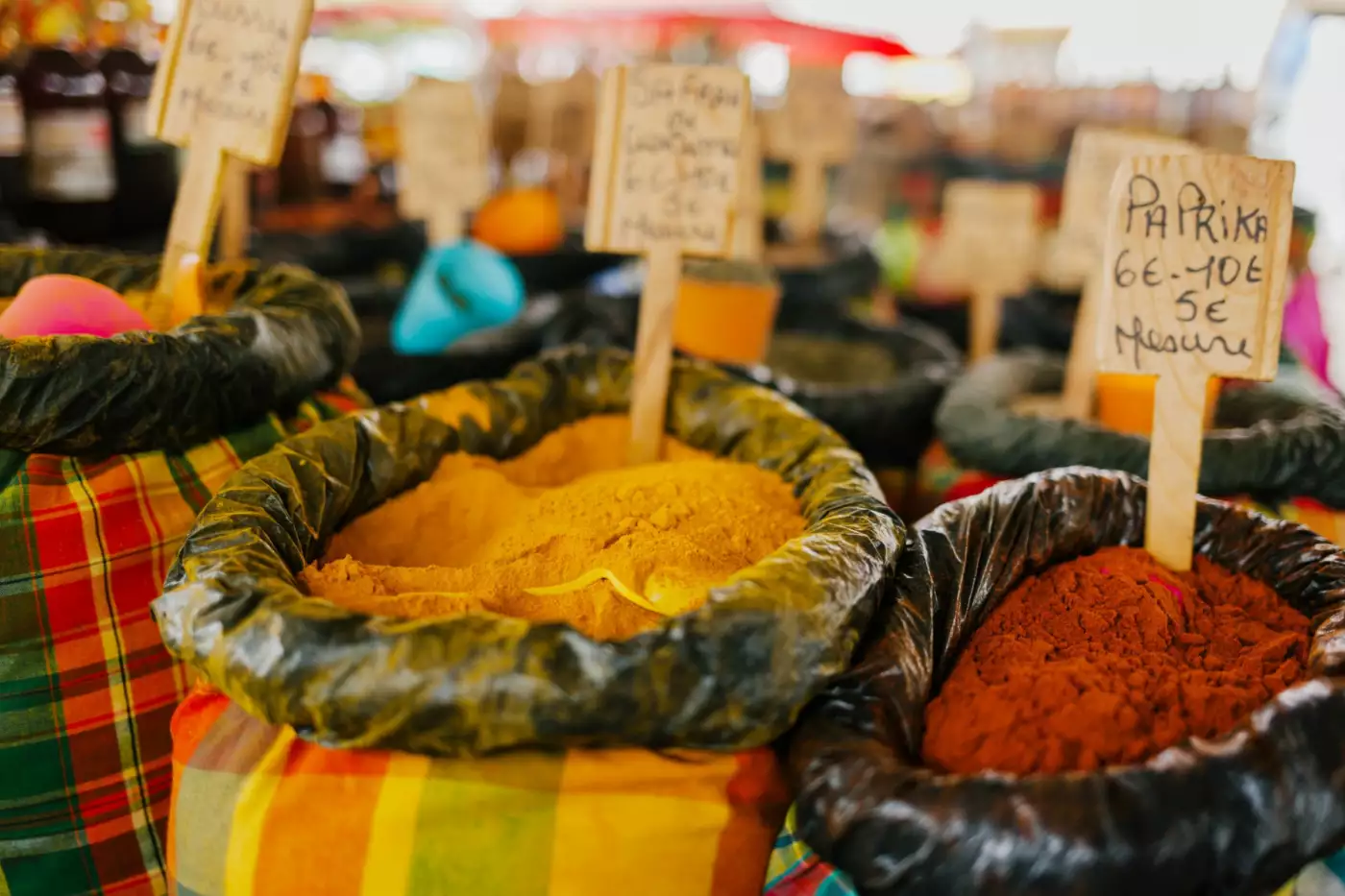 Sacs d'épices colorées alignés sur un étal de marché en plein air